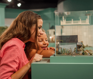 two girls looking closely at exhibit display at museum