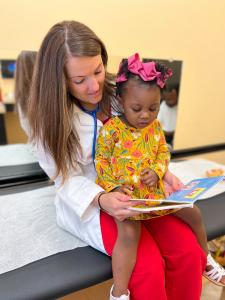 Doctor reading to child as CareSource Doubles Down on Investments in Georgia’s Children