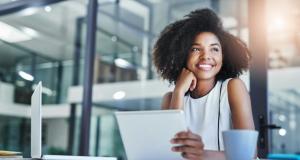 woman smiling in office with tablet