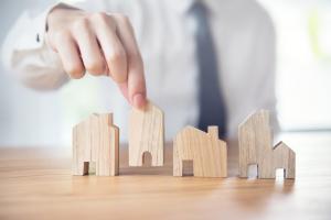 Hand of businessman choosing house model
