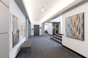 Image of the inside of the Kirkland clinic building. white walls, gray seat, yellow, gray, and blue art on the walls, gray elevator and carpeted staircase.