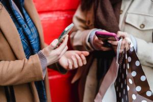 Two people looking at their phones reading text messages.