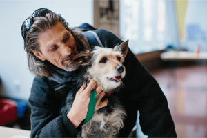 Man with his companion animal at a Feeding Pets of the Homeless sponsored wellness clinic.