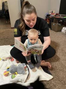 Woman reads BABYBUG Magazine to a young child