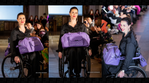 woman on a wheelchair wearing grey clothes wheeling down the catwalk with a purple bag on her lap