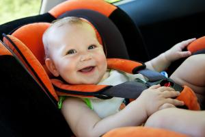 image of a smiling baby in carseat in a backseat of a car