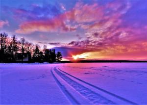 a colorful sunset snowmobile scene