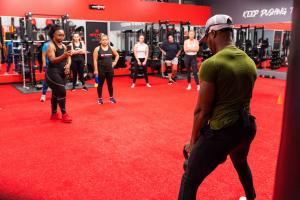 Kwan Sadler Demonstrating Proper Squat Technique During Class at Better Me Fitness and Performance in Aubrey Texas