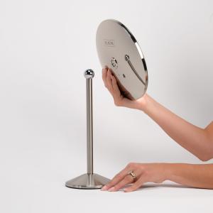 LED cordless mirror is detached from the tabletop or counter stand showing it can be handheld