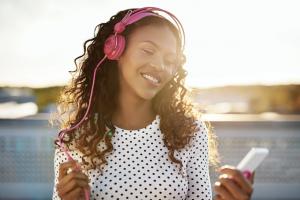 Black female listening to music on headphones