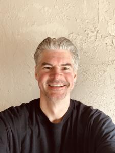 smiling headshot photo of author Sam Stoutman