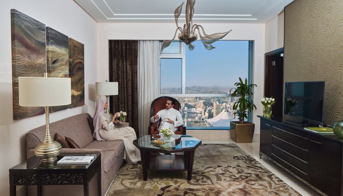 a couple sitting in hotel room enjoying the suite at Makkah Clock Royal Tower, A Fairmont Hotel