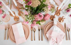 A Contempo Pink themed tablescape for Valentine's Day with flowers and pink napkins.