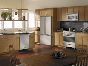 A Viking range kitchen with light wood cabinets and stainless steel Viking 3 Series appliances.