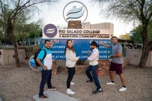 Rio Salado students excitedly point to College sign welcoming you to campus in Tempe, Arizona.