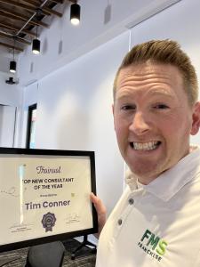 Tim Connor show off his Top Consultant of the Year Award from Trainual.