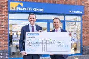 Two managers from The Property Centre holding a cheque for £20,000