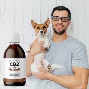 Young male dog owner holding his dog with Cannanda CB2 oil (CB2 Dog-Ease Hemp Seed Oil)