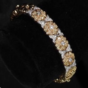 18kt yellow gold and diamond flower and “x” design cuff bracelet with four flowers set with 15 1mm yellow diamonds and one 1mm diamond to each center (est. $1,500-$2,000)