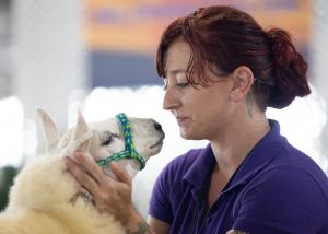 Woman shown sharing affection with an animal.