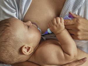 Mom using Neotech Bridge Breastfeeding Assistance Device