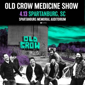Old Crow Medicine Show band members standing outside leaning against a car, laughing.aughing.