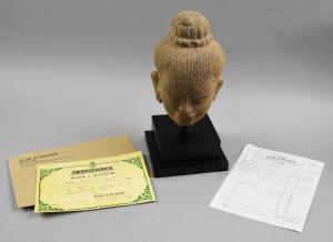 Circa 11th-13th century sandstone Buddha bust from the Baphuon Period in Cambodia, 13 inches tall, with a custom stand and a purchase receipt from 1992 (est. $100-$4,000).