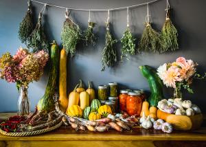 Harvest table with preserves, garlic, peppers and flowers.