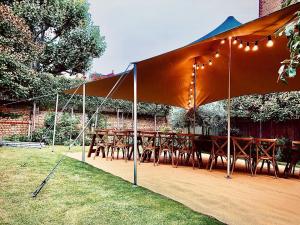 Photo of a spacious and stylish sand-colored stretch tent measuring 10m x 15m, perfect for outdoor weddings and events in France. The tent is made of durable and weather-resistant stretch fabric, which provides guests with shade and protection from the el