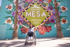 girl in front of visit mesa mural