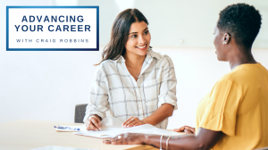 Text: Advancing Your Career with Craig Robbins. Image: Two women in casual work attire facing each other and sitting at a desk with papers and pens.
