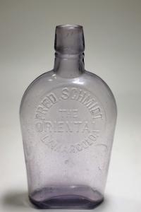 Circa 1894-96 Oriental coffin flask out of Lamar, Colorado, lavender in color, 6 inches tall, with an unmarked base, a top with a collar and a hazy interior ($1,500).