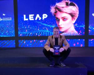 Rick Justus is holding a copy of Abundance Day at the LEAP 2023 event in Riyadh.