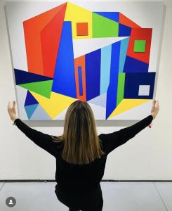 artist in front of colorful abstract painting
