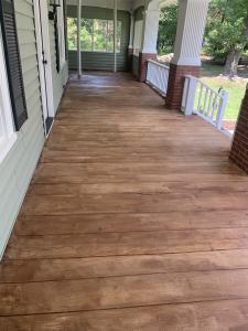A patio with a stunning rustic wood appearance achieved through the use of a durable concrete coating.
