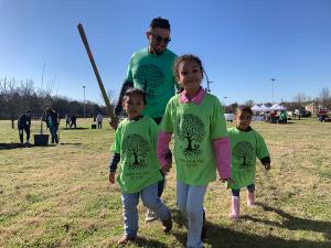 A local area father and his children volunteer to plant trees in Singing Hills Park.