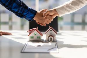 Real estate agents shake hands after the signing of the contract agreement is complete