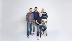The founders of Tuned In Grading pose with the first official graded record. From left to right:  Jeff 'Skin' Wade,  Rogers Healy, Luke Sardello, and Waric Cameron.