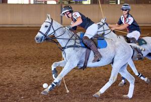 arena polo player on a gray horse carries the ball in National Interscholastic Championship