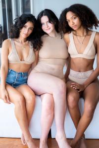 Three women wearing Higher Loyalty undyed organic cotton lace lingerie.