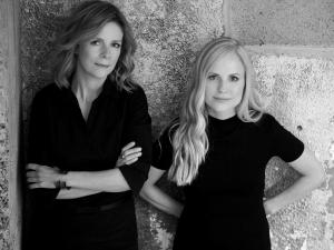 The women posing for the camera in front of cement wall