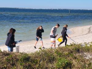 Students collecting marine debris on a beach