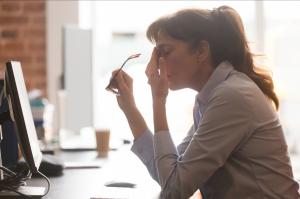 A professional woman is stressed because it is hard to be a leader in the post pandemic workplace