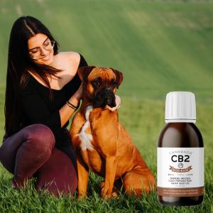 Woman crouching down with dog in a field with Dog-Ease CB2 oil