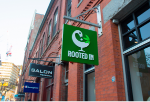 The image shows the exterior of the BIPOC owned dispensary Rooted In located on Boston's famous Newbury Street