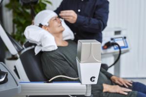 MagVenture Atlas pulse electromagnetic transmitter with patient in background