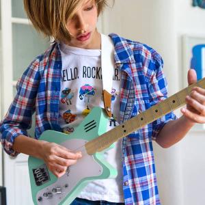 Kid plays Loog Pro 3-string electric guitar in green