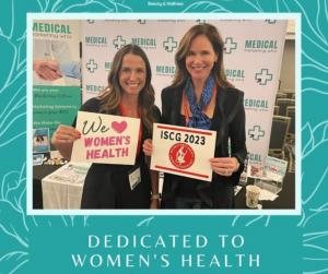 photo of Dr. Lori Warren and Lori Werner standing and smiling holding women's health signs