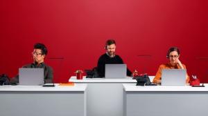 Three business workers using VoIP phone systems to conduct business.
