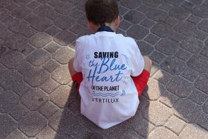 Little boy picking up trash during the Vertilux Beach Clean Up in 2021